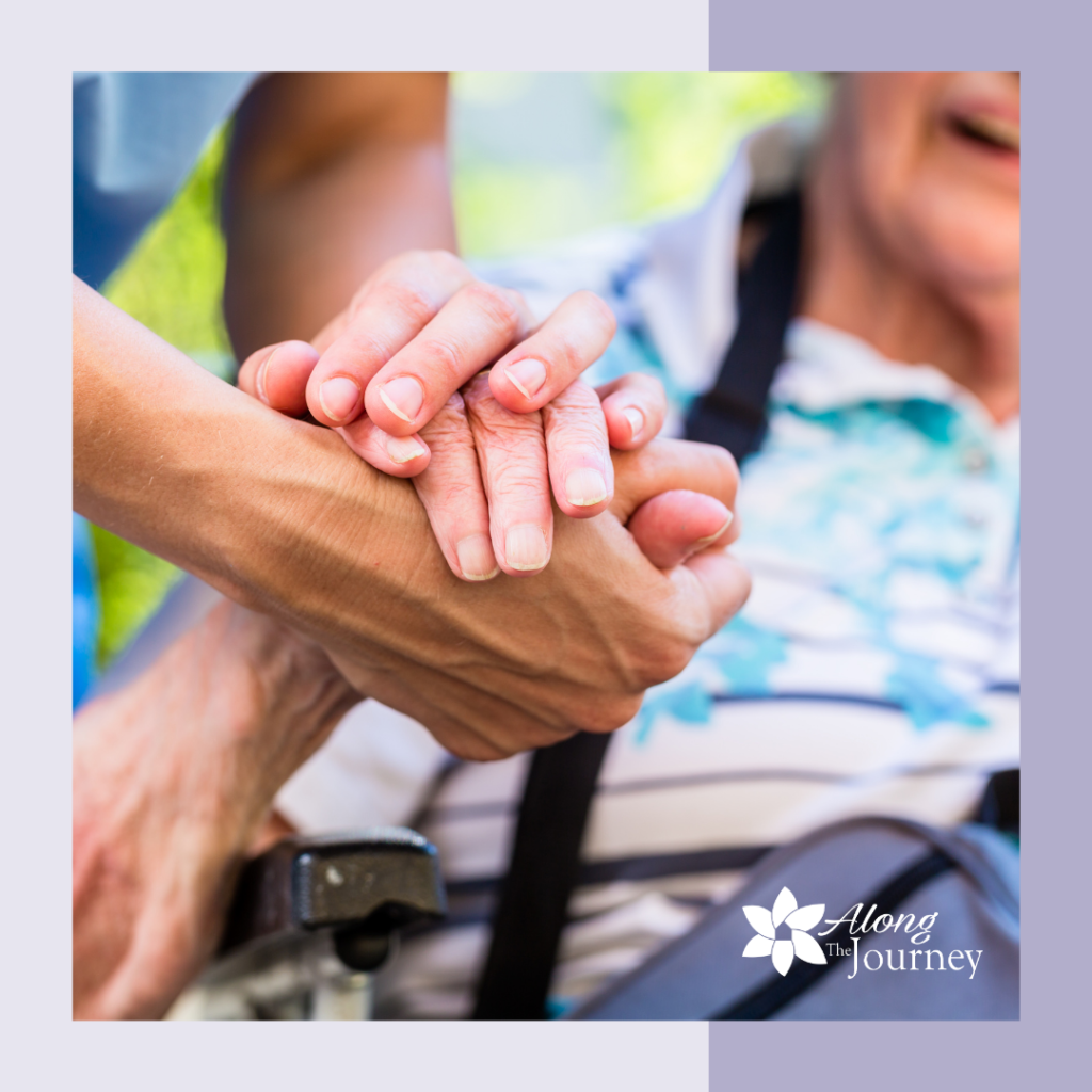 Senior woman with her hand being held by a caregiver