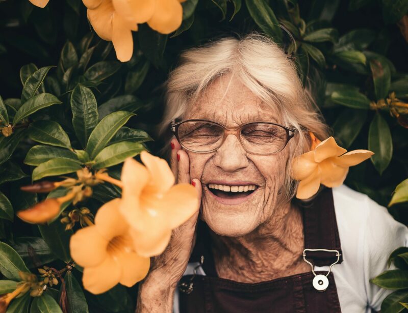 Caucasian woman smiling amid orange flowers