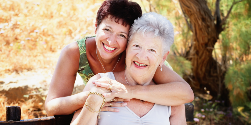 Caucasian mother and daughter smiling for choosing senior living.