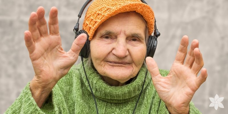 Caucasian senior woman listening to music through headphones.