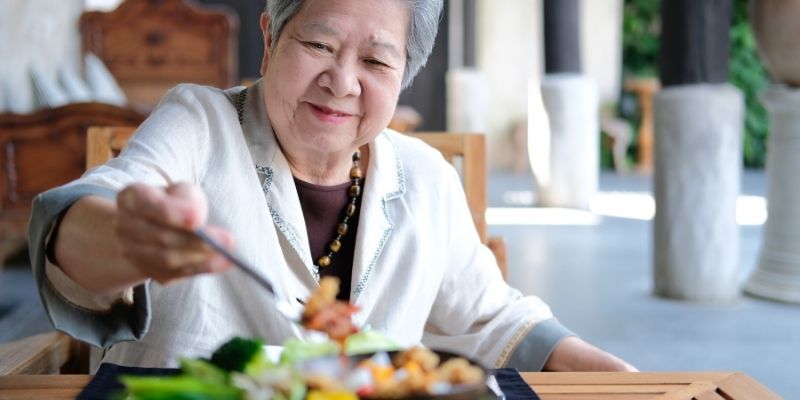 Asian woman dining at Celebration Villa