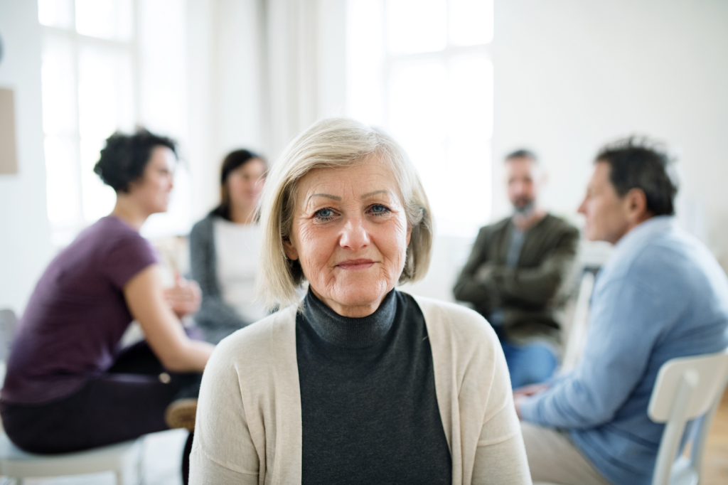 Senior woman sitting in a mental health group