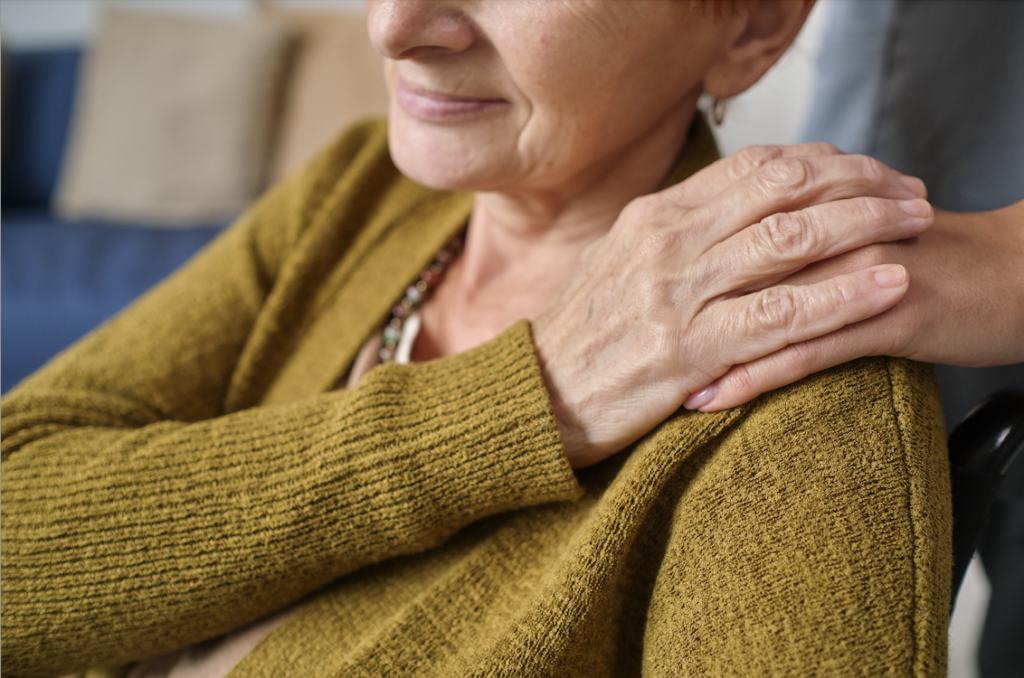 Senior woman with hand on her shoulder