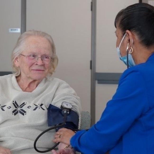 healthcare worker getting blood pressure reading of a senior woman