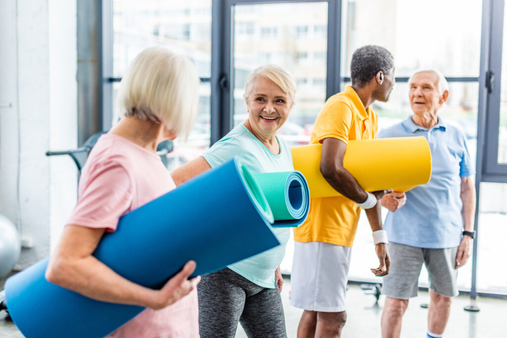 Seniors sports people holding their fitness mats