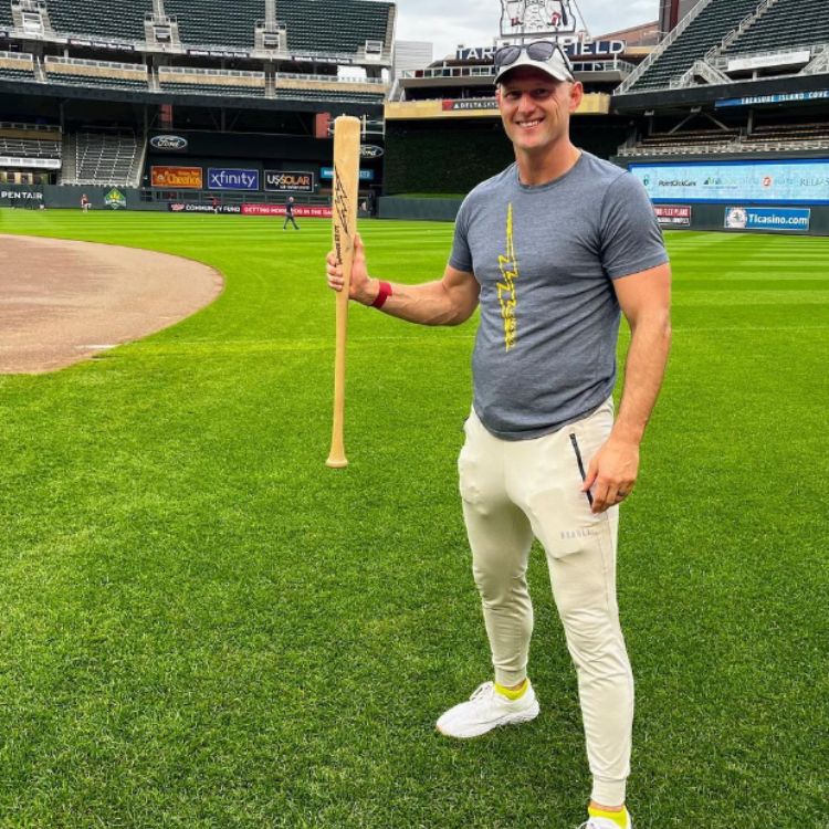 Bobby Petras holding baseball bat on field in a stadium.