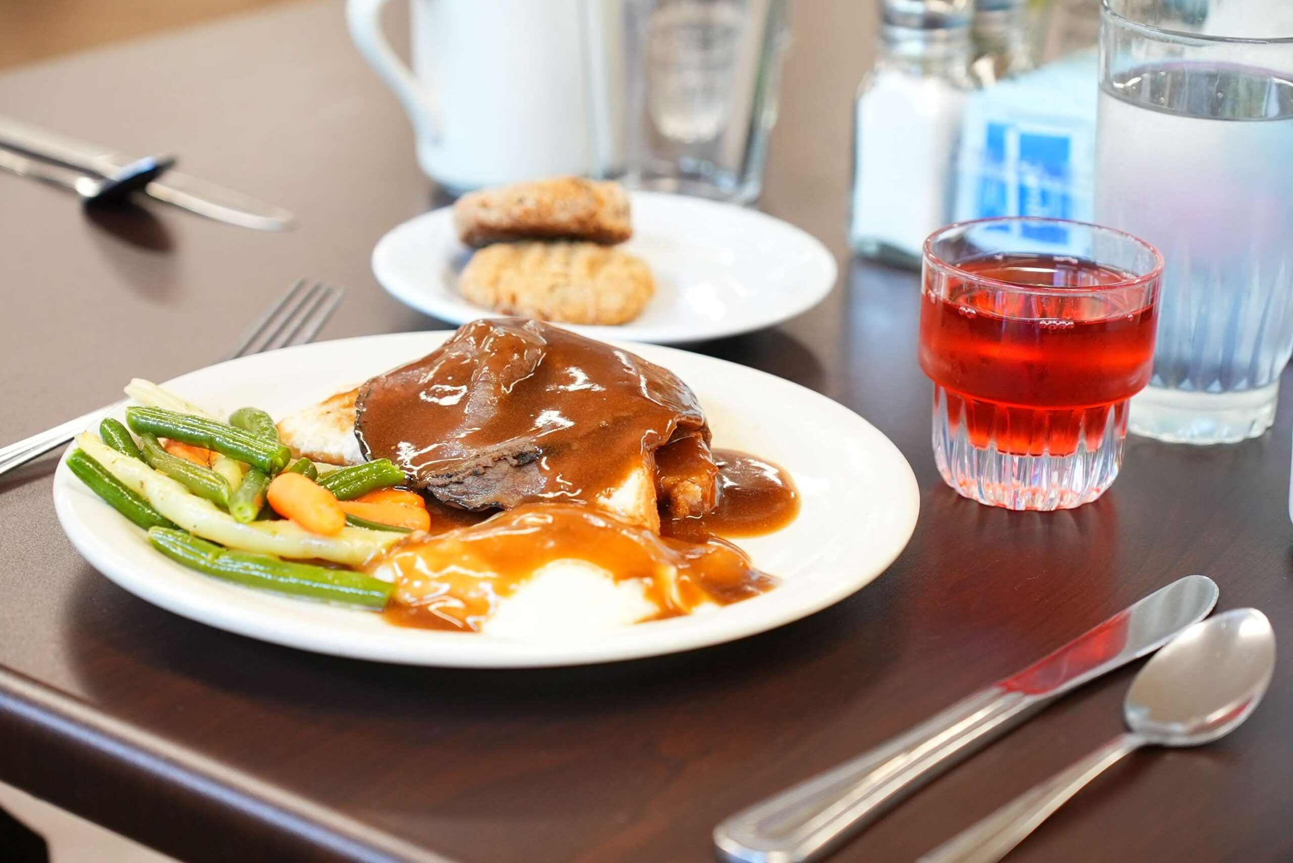 Roast beef, mashed potatoes, and mixed vegetables with gravy.