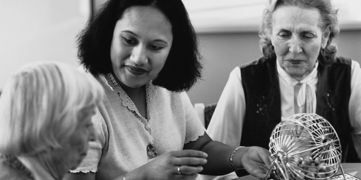 Black and white photo of a caregiver with two senior women