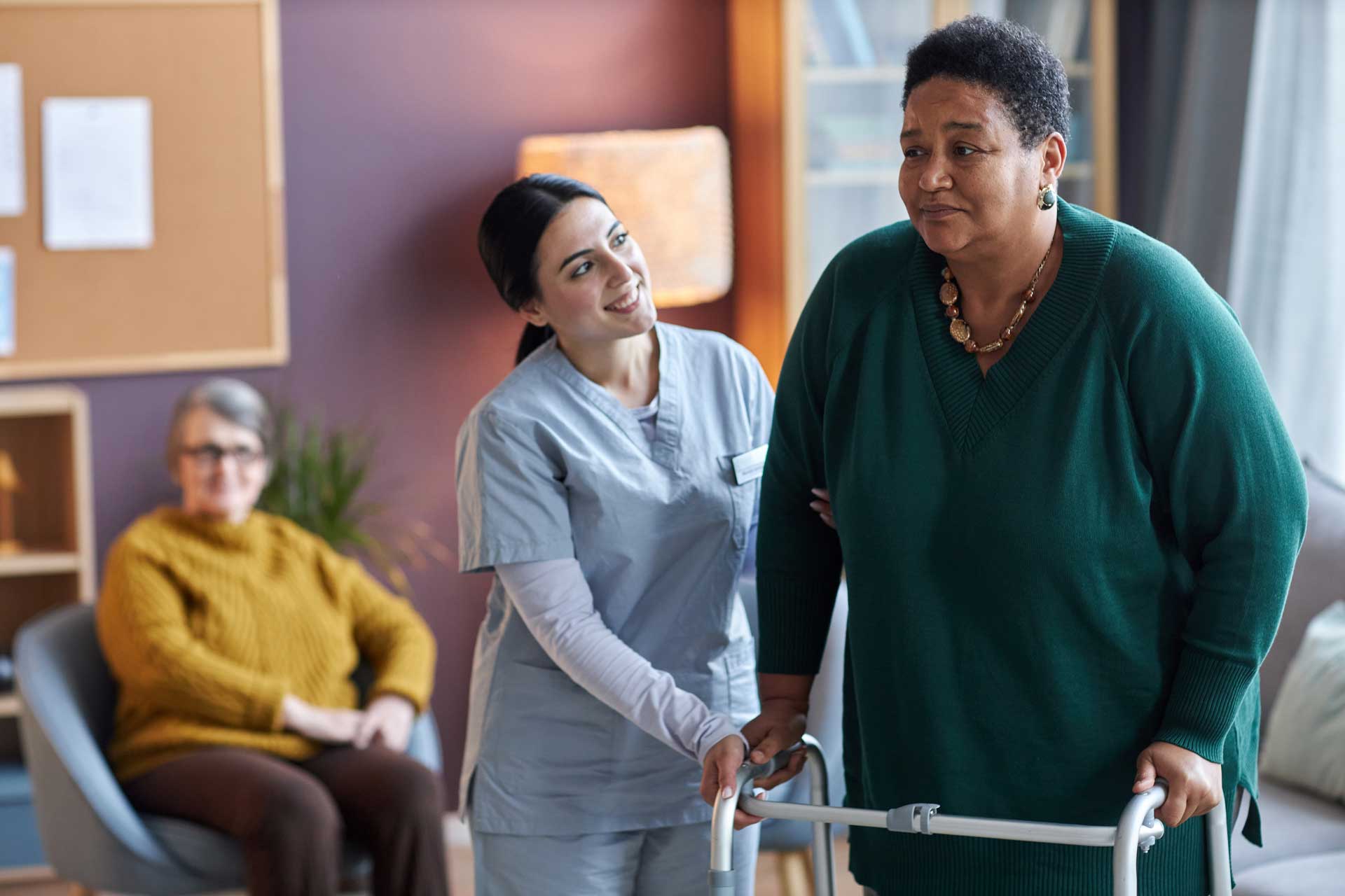 A senior woman being assisted by a caregiver