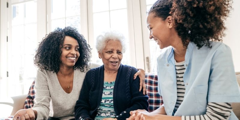 Senior woman sitting wither her family