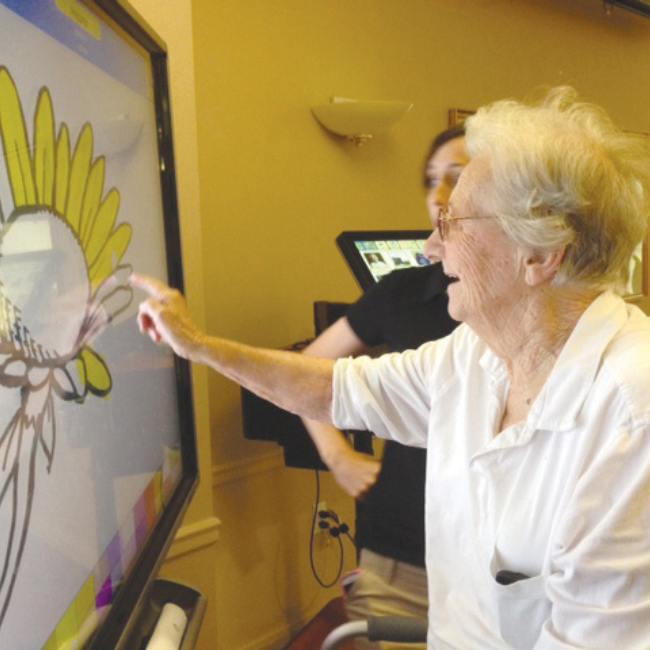 Senior woman painting on a screen