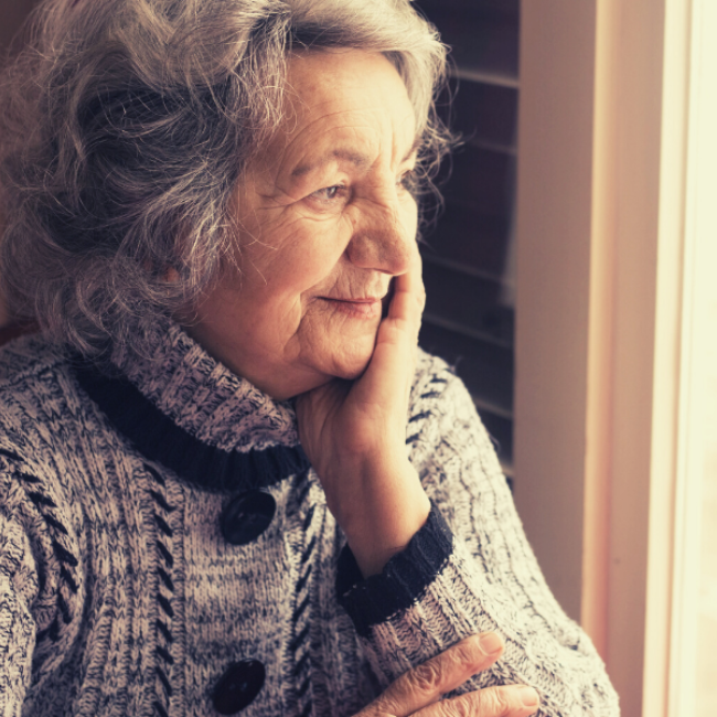 Senior woman smiling and looking out a window