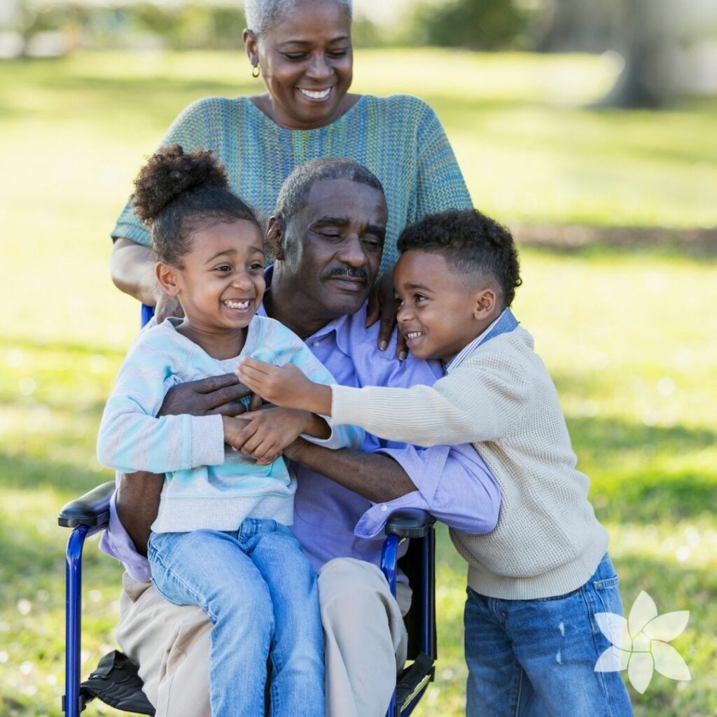 senior man in wheelchair hugging his grandchildren