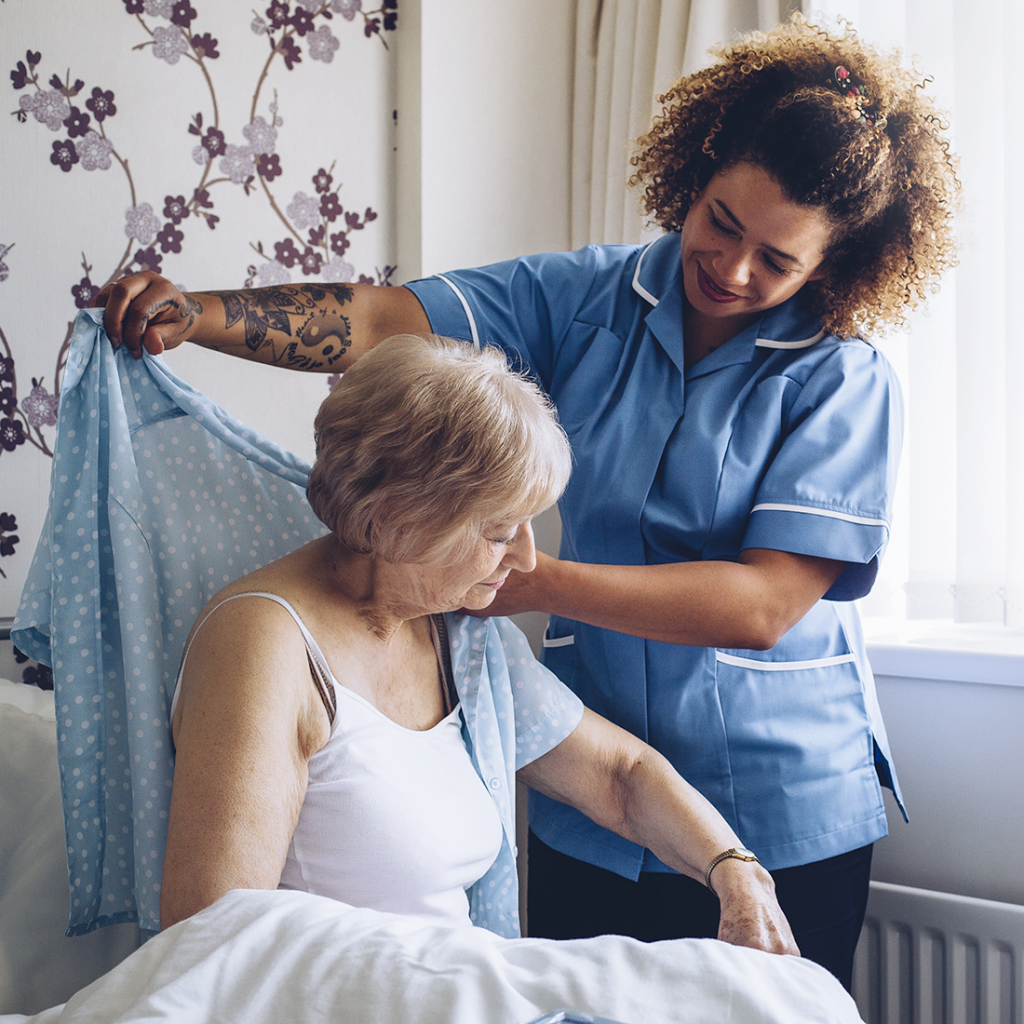 Senior woman getting assistance getting dressed